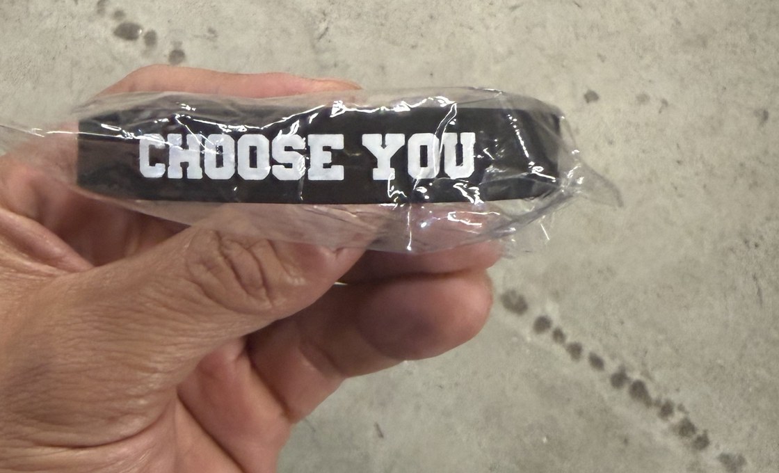 A Choose You wristband held in hand